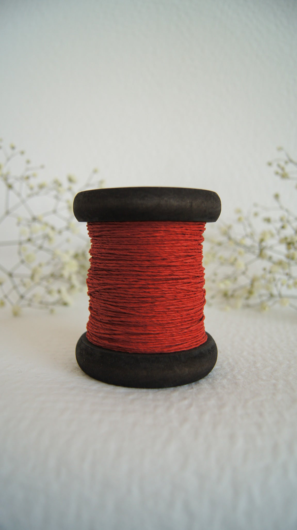 Thick paper yarn on wooden bobbin