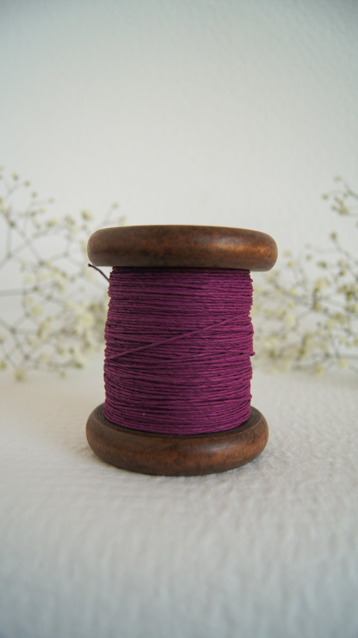 Thick paper yarn on wooden bobbin